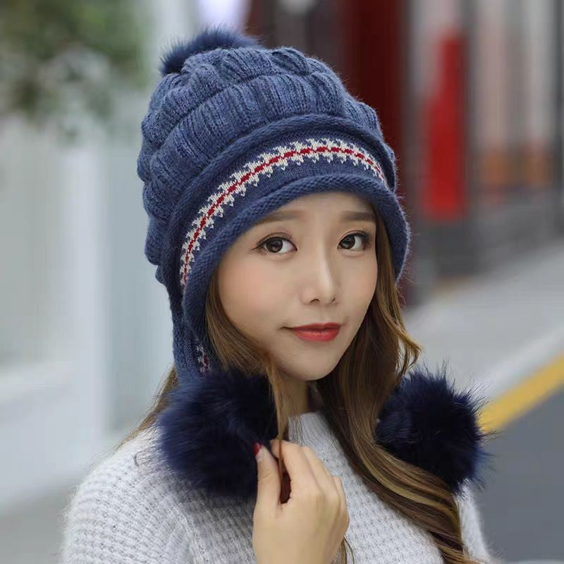Woman in a knitted bobble hat with ear flaps